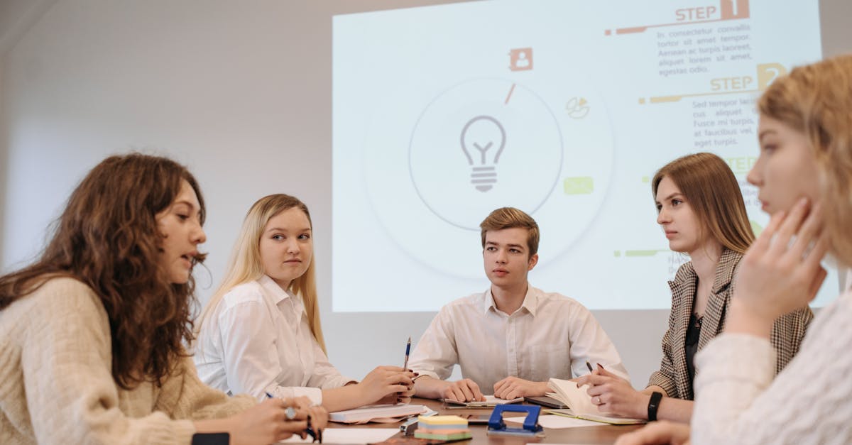 A diverse group of young professionals in an office discussing a business presentation.